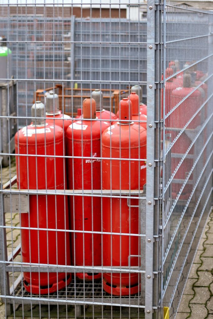 Red LPG cylinders in a storage cage